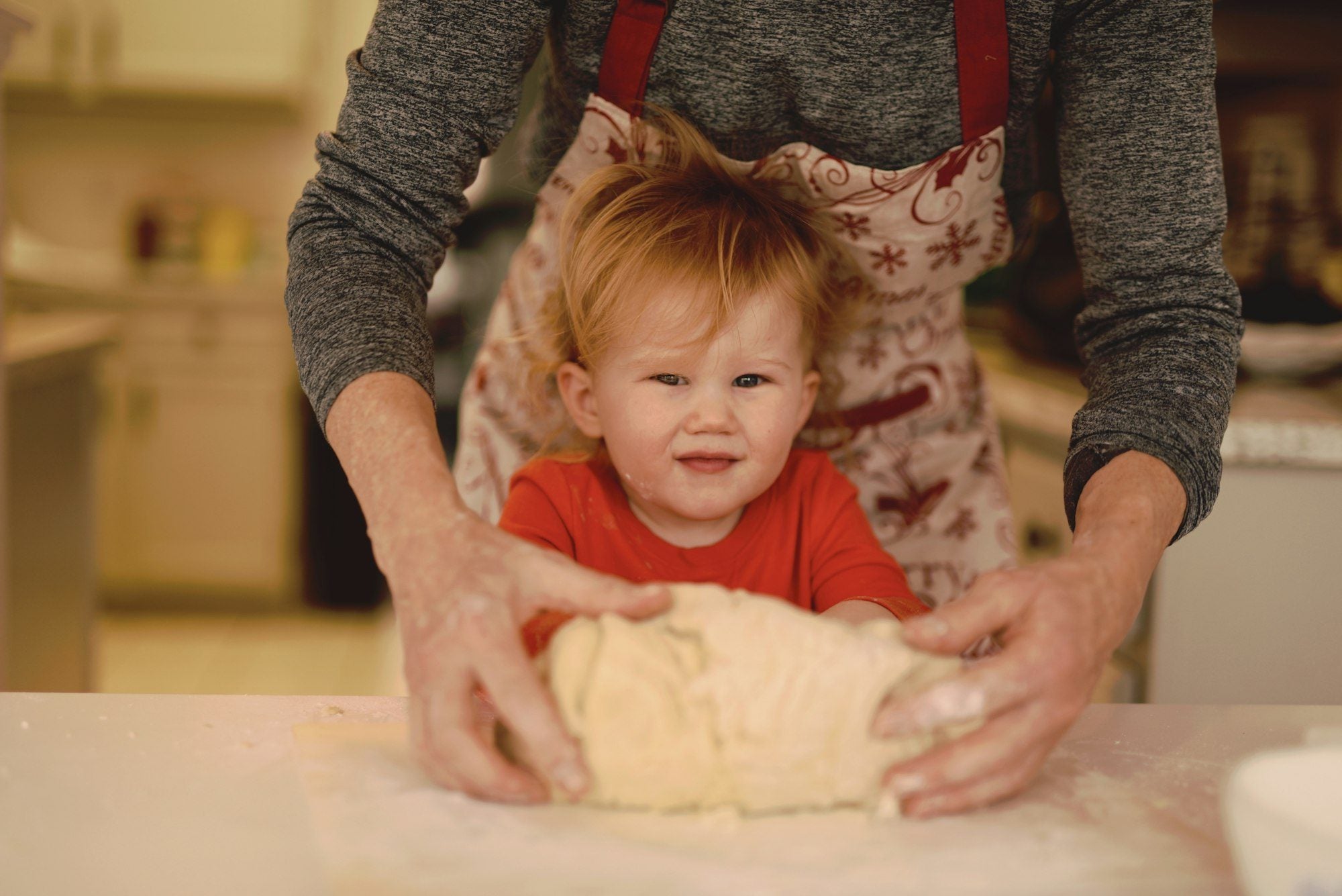 A parent and toddler baking together at home