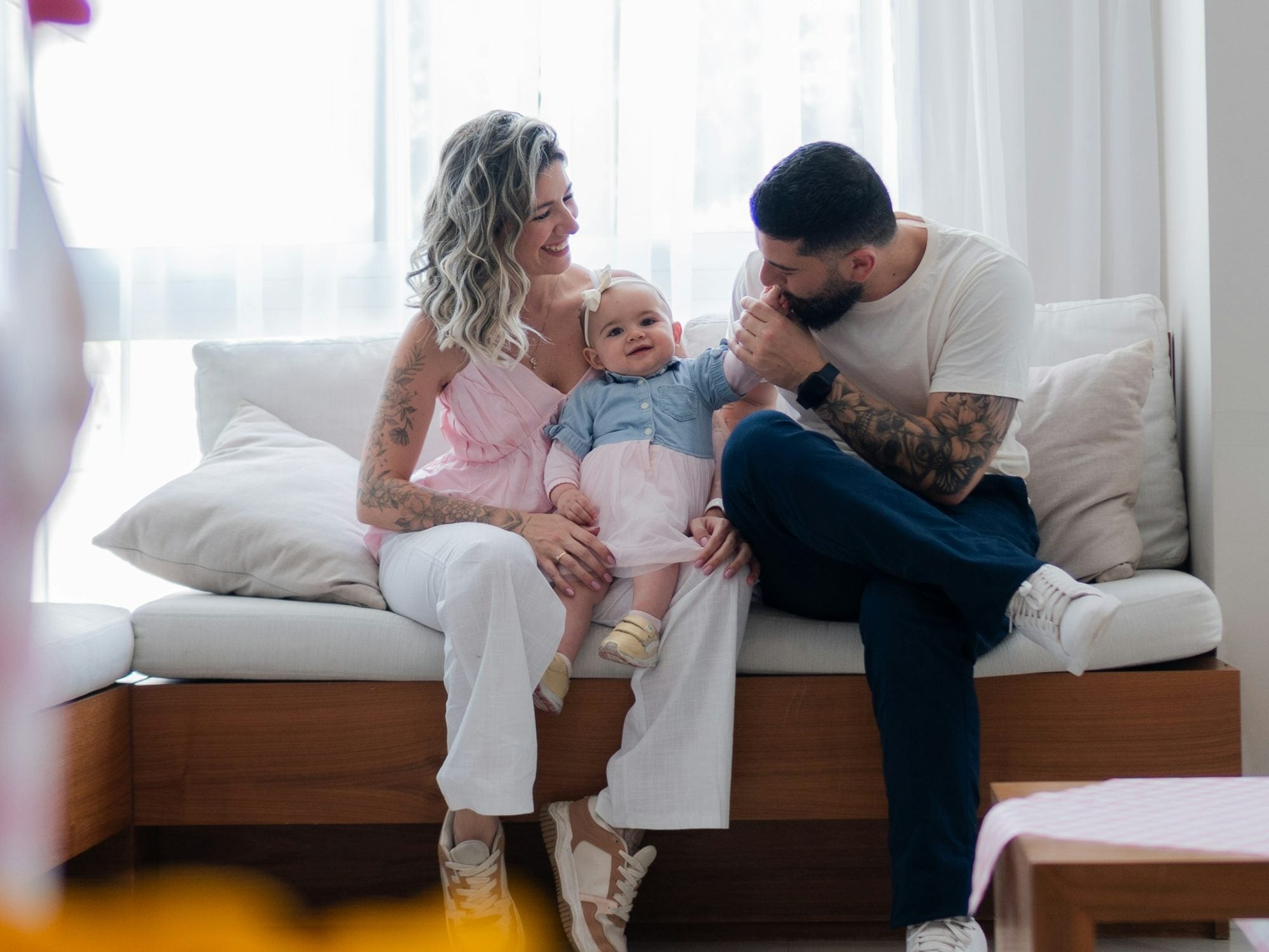Two parents with their baby on the sofa