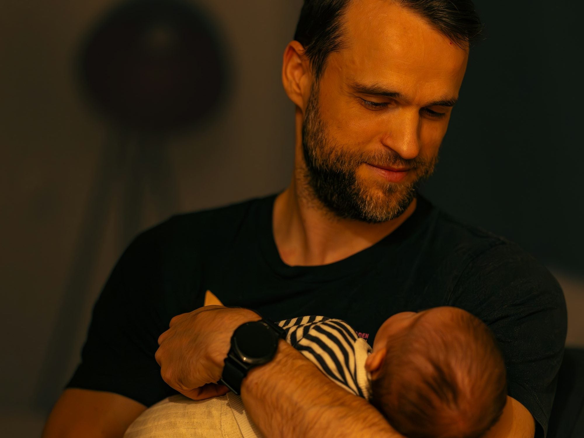 A dad holding his newborn in the evening